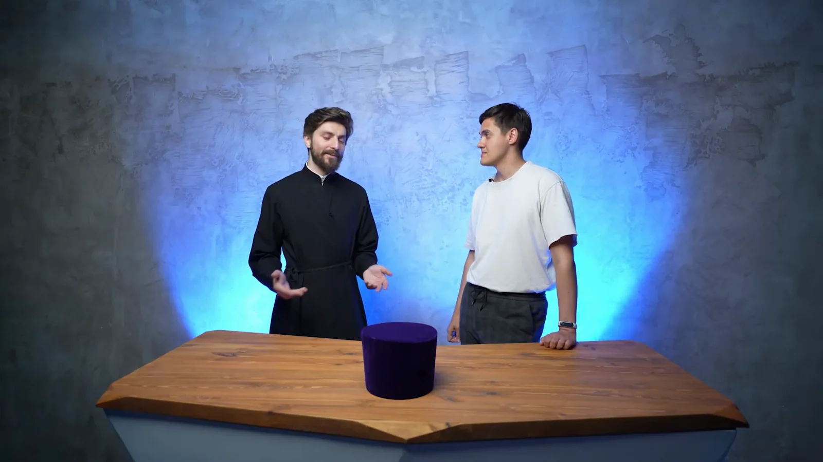 Ivan hosts Orthodox Unboxing with a priest in a blue-lit studio